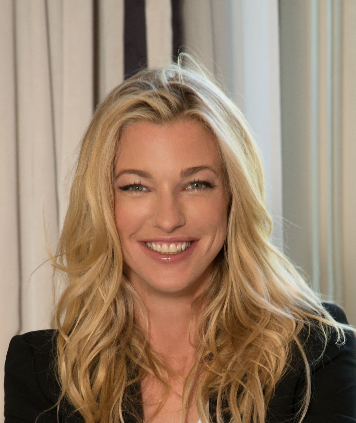 Nicole Junkerman smiling warmly in a bright, close portrait